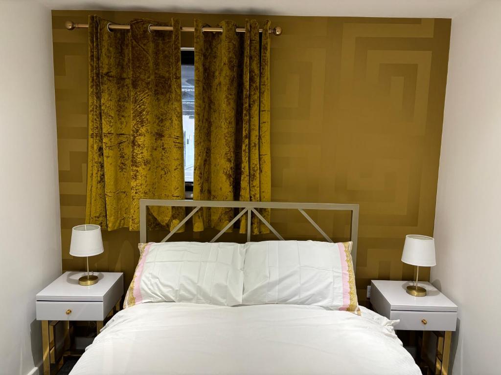 a bedroom with a bed with two night stands and two lamps at Versace The Malt House in Burton upon Trent