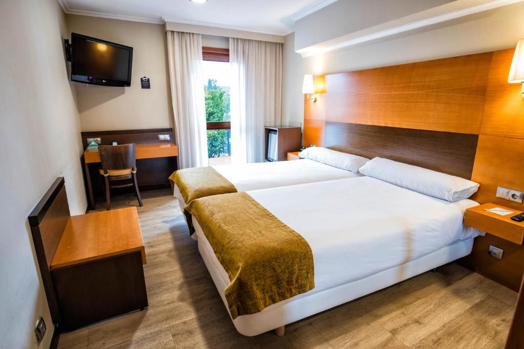 A bed or beds in a room at Hotel Alda Bonaval