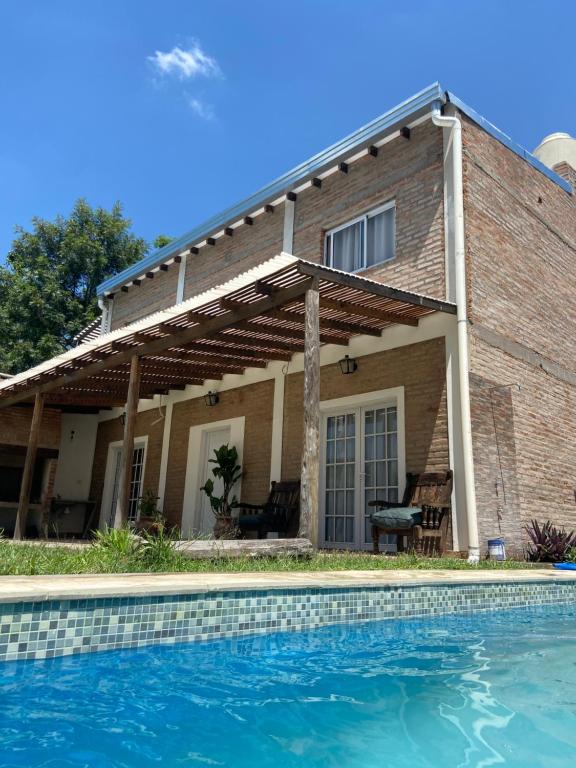 ein Haus mit Pool davor in der Unterkunft La Quinta San Cayetano in Laguna Brava