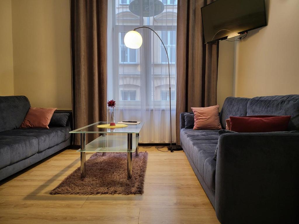 ein Wohnzimmer mit einem Sofa und einem Glastisch in der Unterkunft AMBER APARTAMENt #10 in Krakau