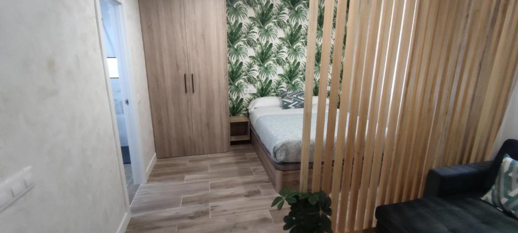 een slaapkamer met een bed en een houten vloer bij Apartamento Centro A in San Sebastián de los Reyes