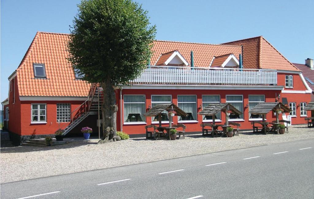 a red building with tables and chairs in front of it at Lejl, 3 in Kegnæshøj