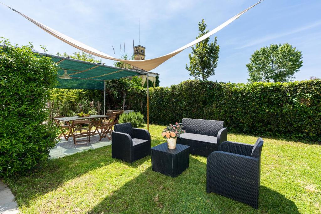 giardino con 2 sedie, tavolo e tenda di Beach House with private garden a Marina di Pietrasanta