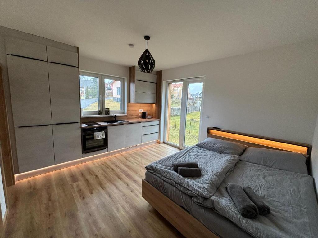 ein Schlafzimmer mit großem Bett und eine Küche in der Unterkunft Apartmány u pláže Lipna - Malé Lipno in Černá v Pošumaví