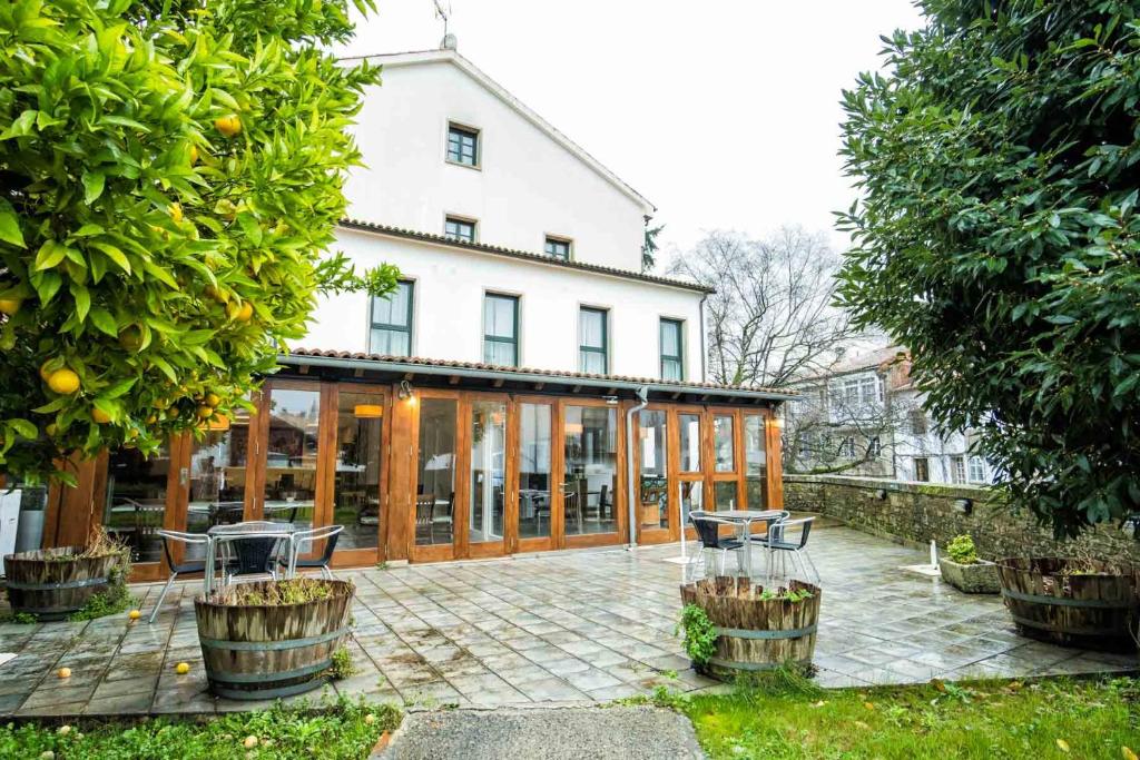 a large white house with a patio in front of it at Hotel Alda Bonaval in Santiago de Compostela