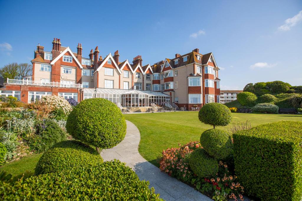 a large house with a garden and bushes at Hydro Hotel in Eastbourne