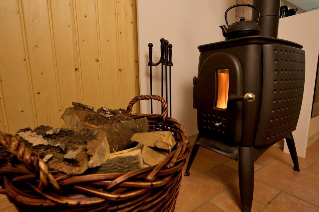 a black stove sitting next to a basket of rubble at Berghütte mit Finnischer Blockhaussauna in Bielatal
