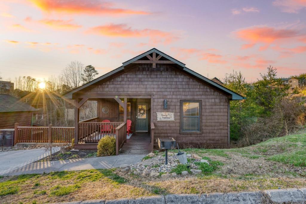 een klein huis met een veranda en een zonsondergang bij Bear Cove by AvantStay Hot Tub Pool Table in Pigeon Forge