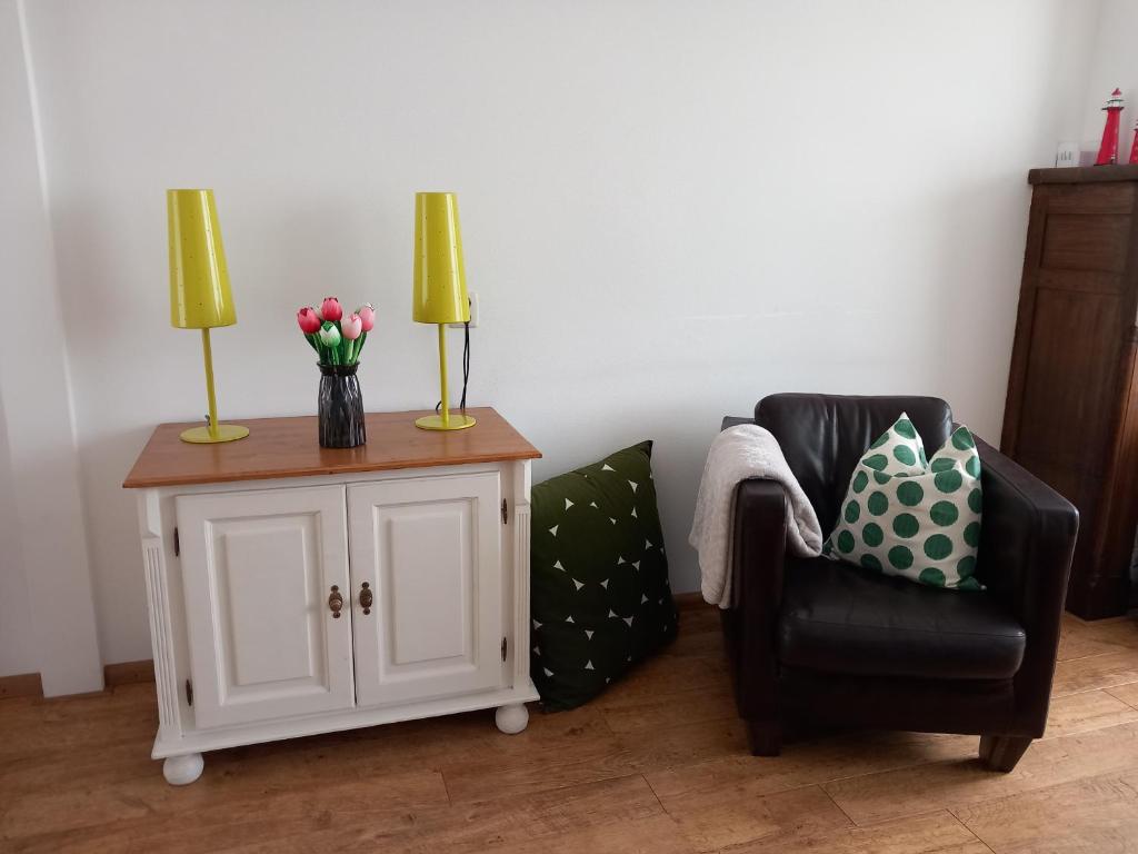 een woonkamer met een stoel en een tafel met 2 lampen bij Appartement AanZee in Hoek van Holland