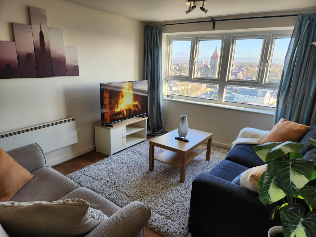 a living room with a couch and a tv at City View Salford in Manchester