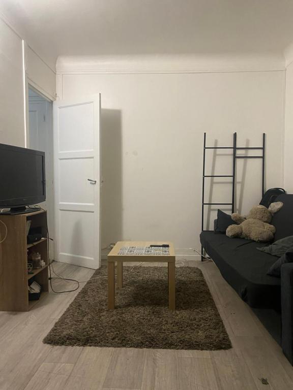 un salon avec un canapé et une table basse dans l'établissement Grand studio 30M2 Asnières sur Seine Centre-Ville, à Asnières-sur-Seine