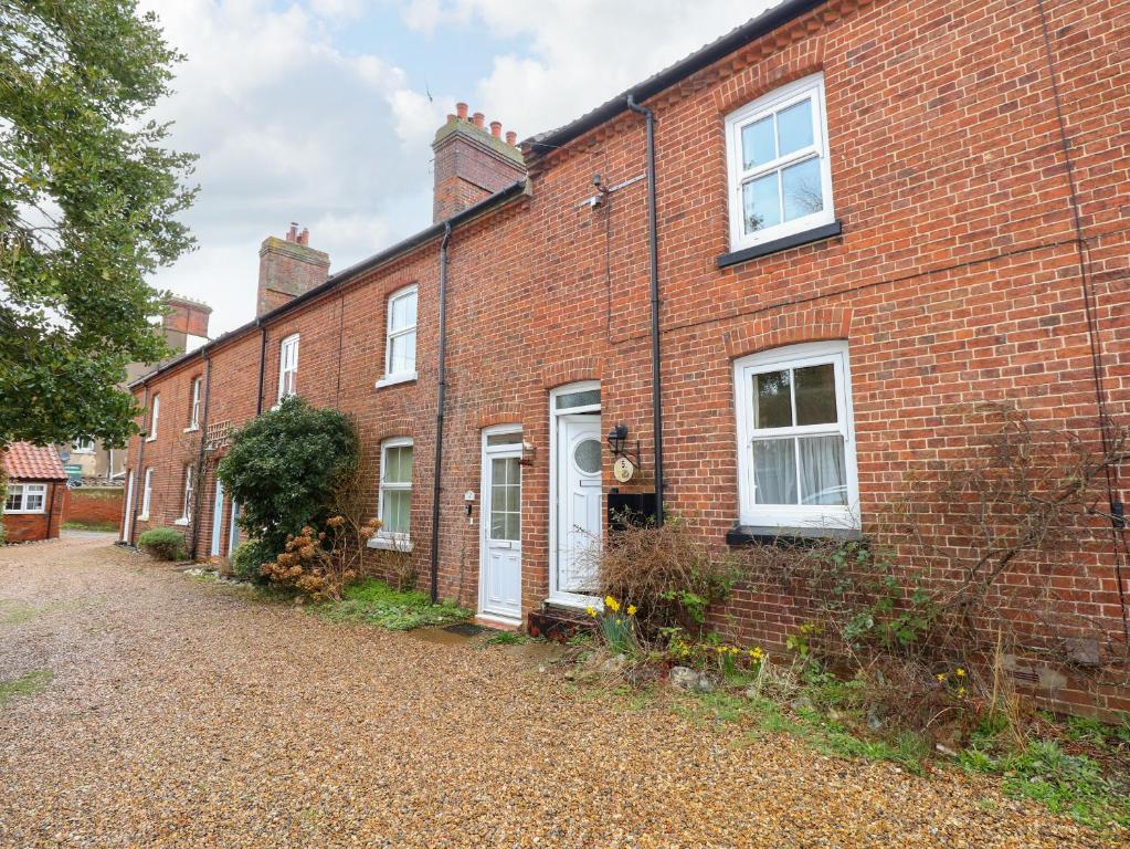 a red brick house with white doors and windows at 5 Melinda Cottages in West Runton
