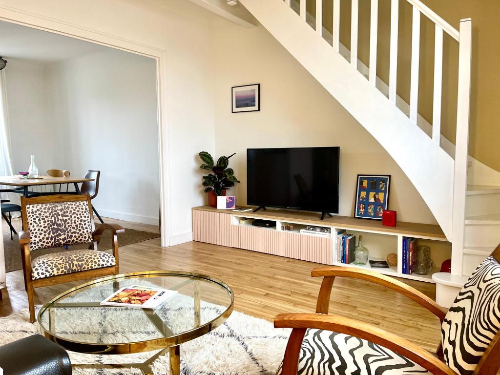 een woonkamer met een tv en een glazen tafel bij Le 30 Rennais - T4 en plein centre ville in Rennes