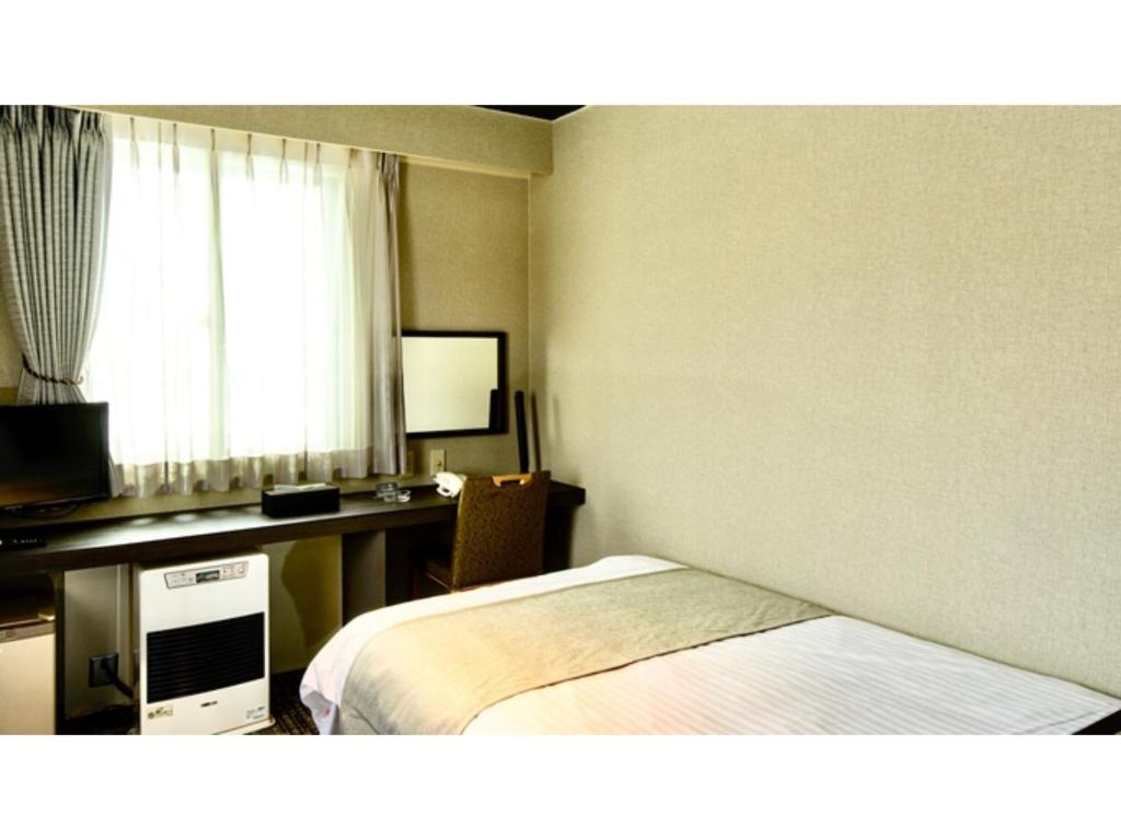 Hotel Three M - Vacation STAY 93397v في كوتشان: غرفة في الفندق مع سرير ومكتب