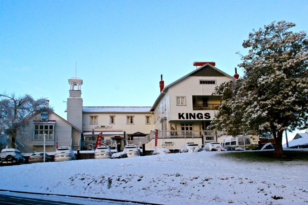 un gran edificio blanco con coches aparcados en la nieve en Kings Ohakune, en Ohakune