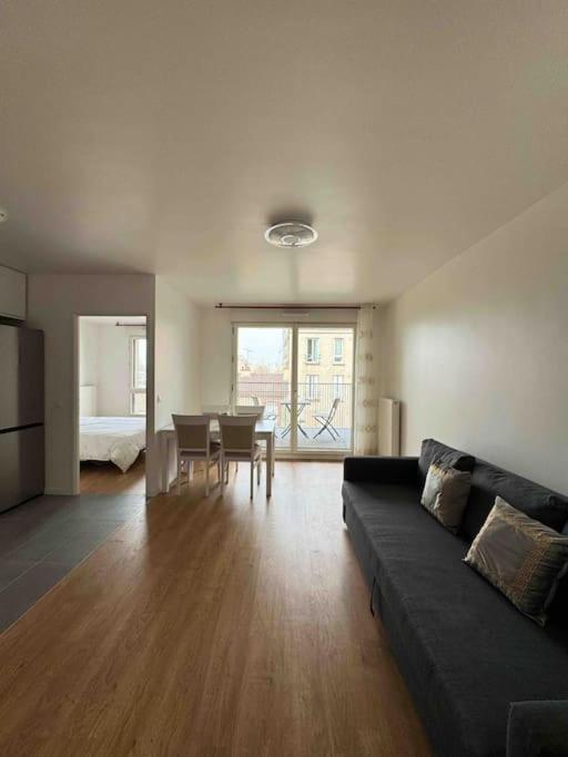 - un salon avec un canapé et une table à manger dans l'établissement Appartement moderne avec Balcon proche de Paris, à Aubervilliers