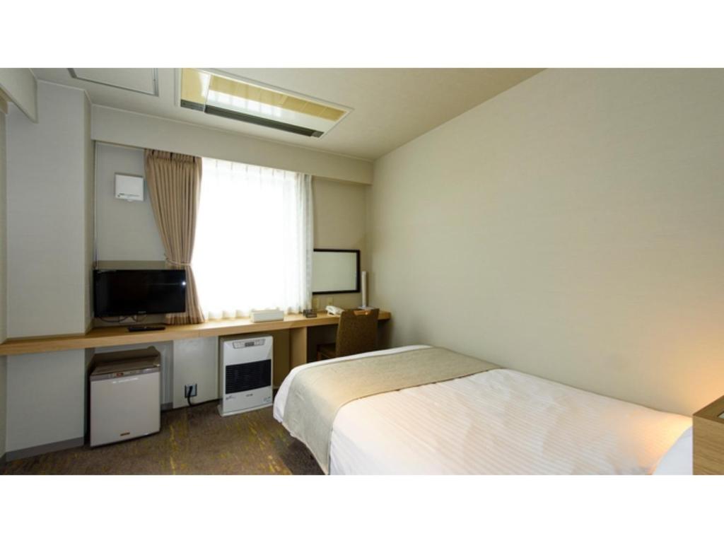 Habitación de hotel con cama y TV en Hotel Three M - Vacation STAY 93394v en Kutchan