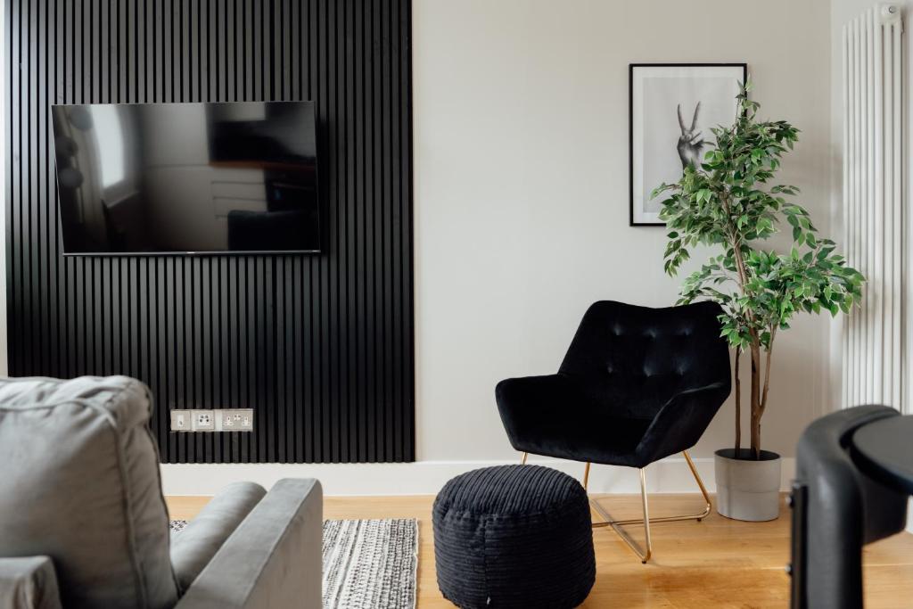 uma sala de estar com uma cadeira e uma televisão em Contemporary & Chic 1 Bedroom Apartment in Honor Oak em Londres