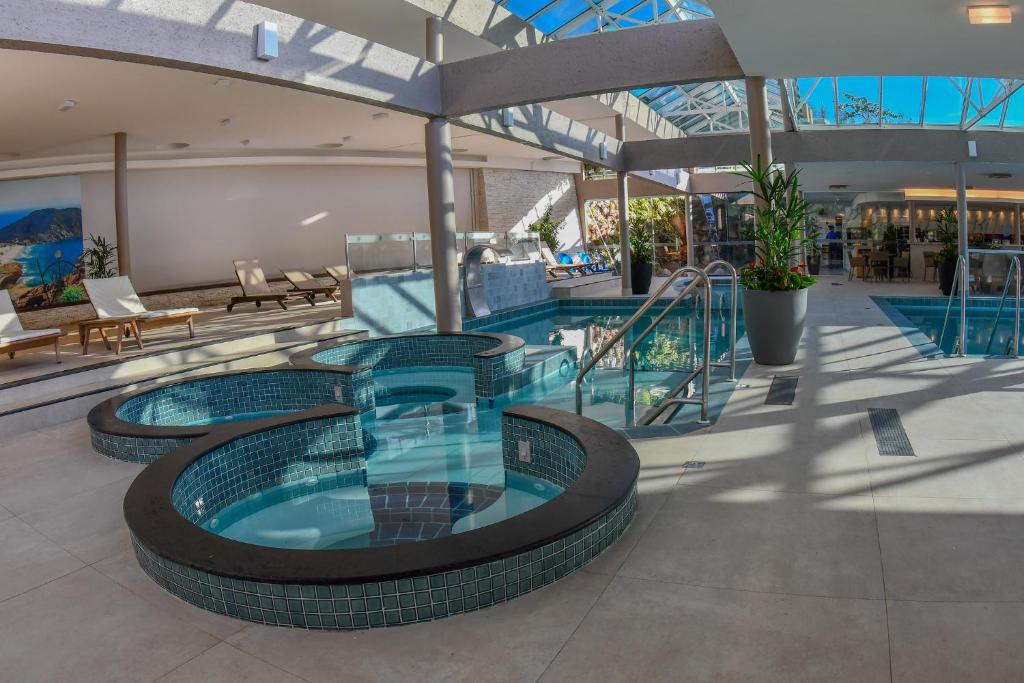 a large swimming pool in a building at Costao do Santinho Resort All Inclusive in Florianópolis