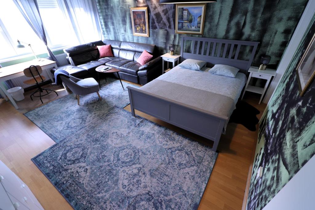 een slaapkamer met een bed en een bank bij Naomi app,Netflix,between bus and train station in Zagreb