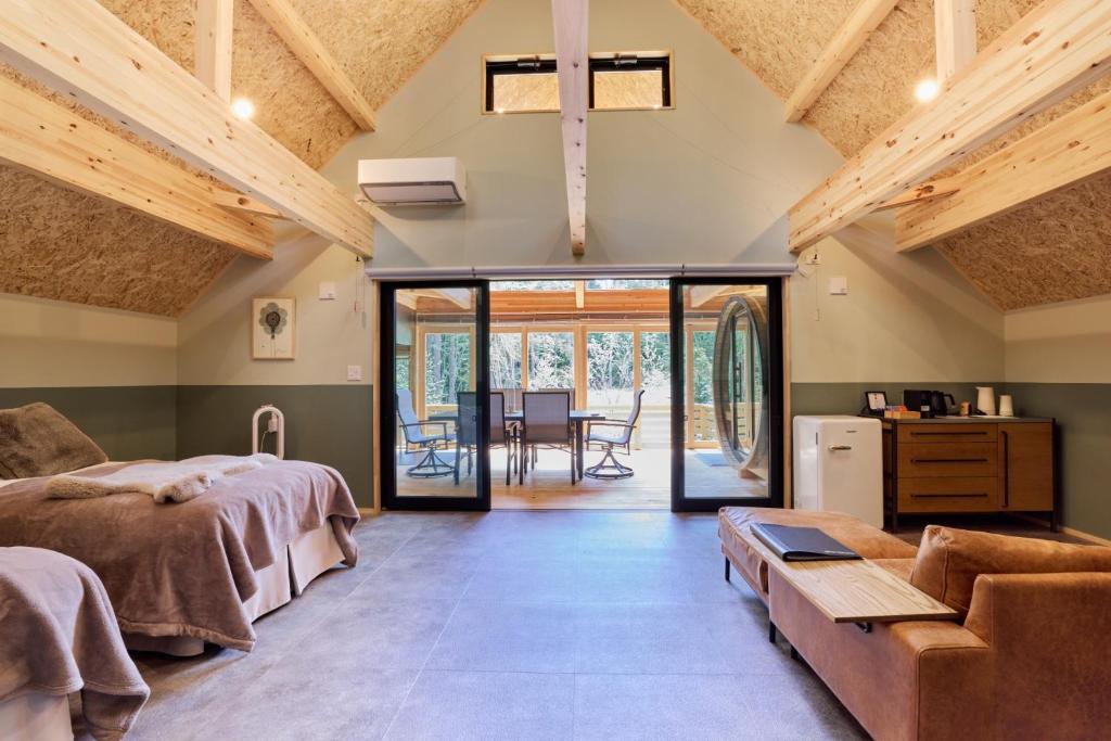 a bedroom with two beds and a couch and a table at GRAN TOCORO, RESORT&GLAMPING - Vacation STAY 84986v in Narusawa