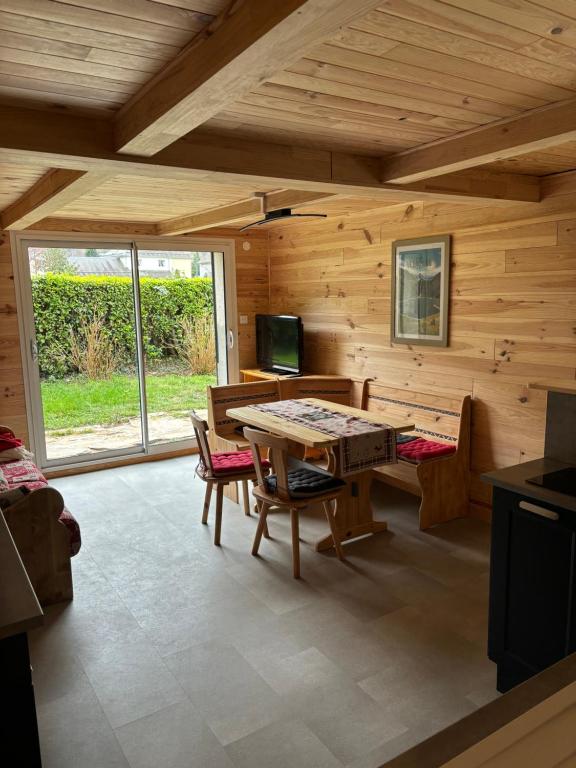 un salon avec une table, des chaises et une télévision dans l'établissement L'OURSIERE à Saint MAMET, à Saint-Mamet