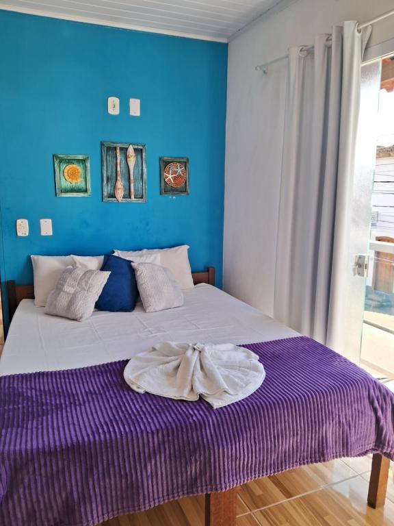 a bed in a room with a blue wall at Pousada Caminho do Mar in Paraty