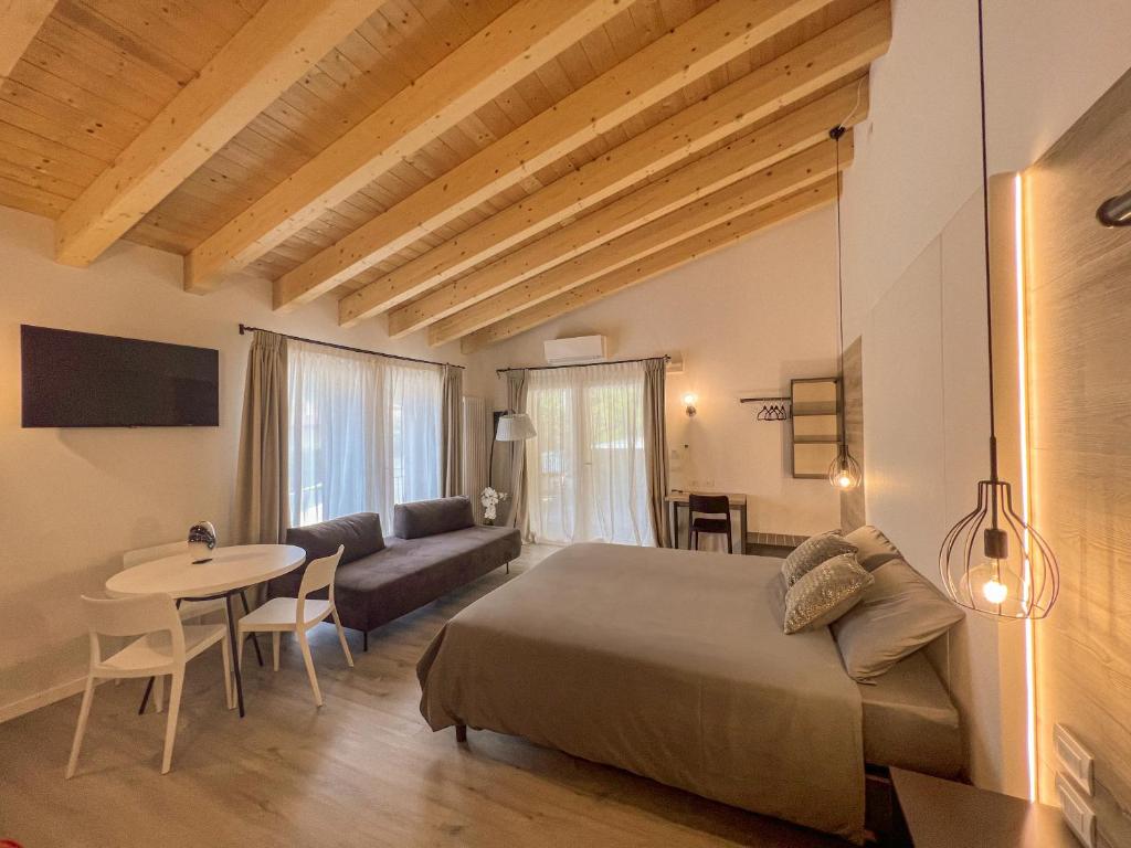 Fregona的住宿－Albergo Ristorante Fratte，一间卧室配有一张床、一张桌子和一张沙发