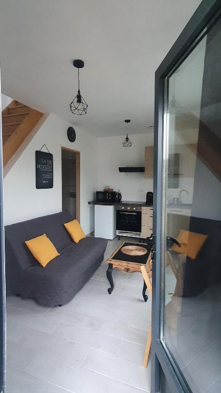 uma sala de estar com um sofá e uma mesa em Charmant T2 tout confort proche centre ville. em Milly-la-Forêt