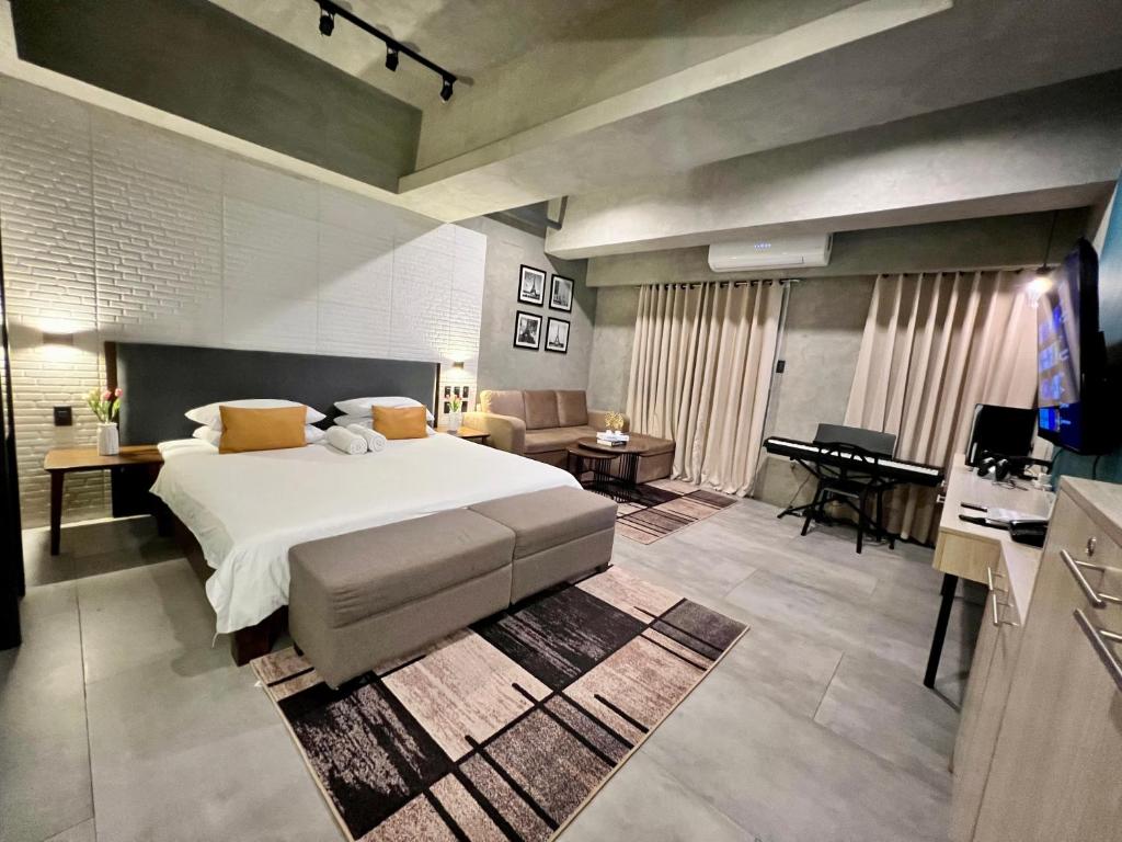 a bedroom with a bed and a living room at Cozy Spacious Hotel Type Condo with PS5 Smart TV and WiFi in Manila