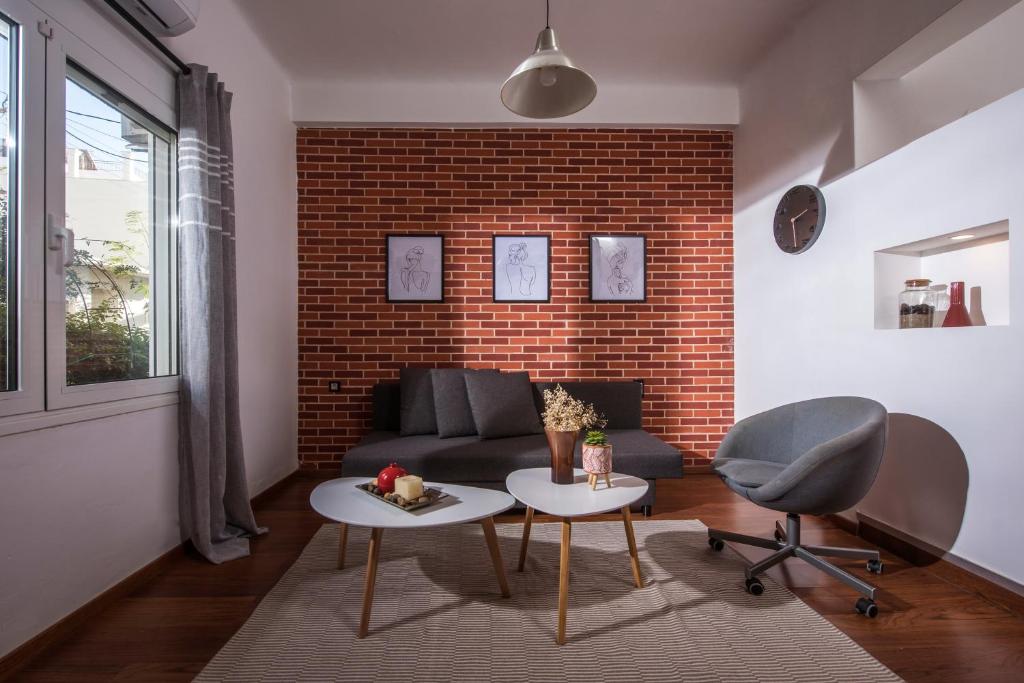 City Cave Apartment في مدينة هيراكيلون: غرفة معيشة مع أريكة وجدار من الطوب