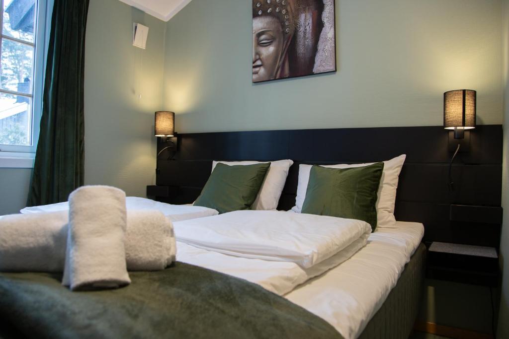 2 camas en una habitación con sofá en Tune Hotell Sarpsborg, en Sarpsborg