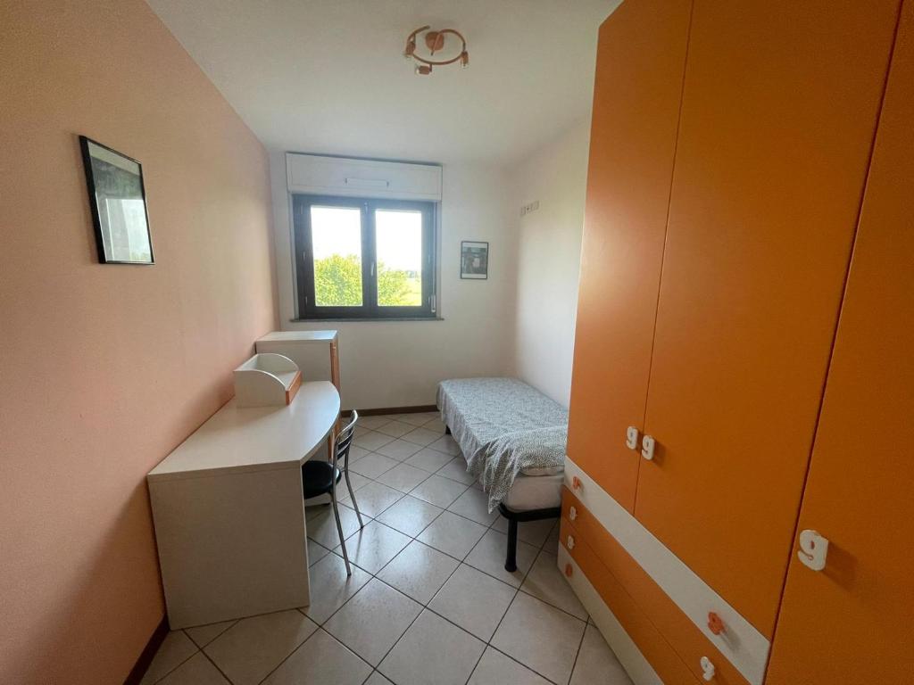 Habitación pequeña con cama y ventana en Camere Rozzano, vicino Humanitas, en Rozzano