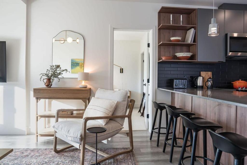una cucina con bar, sedie e tavolo di Snowed Inn - Stunning 3 Bedroom Condo a Revelstoke