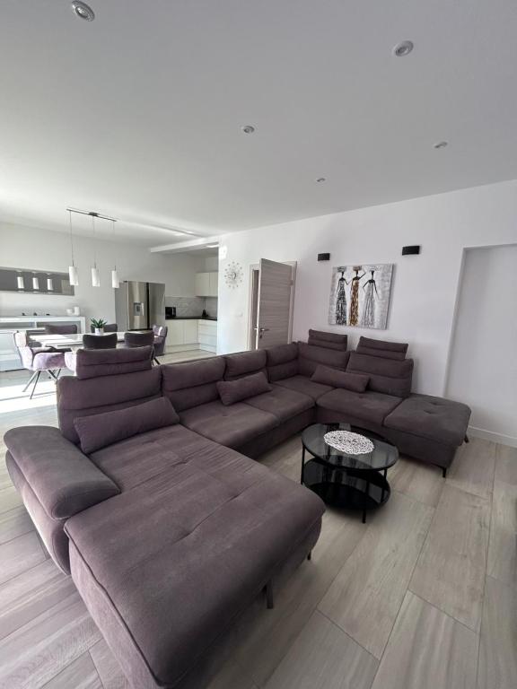 uma sala de estar com um grande sofá castanho e uma mesa em Stunning apartment Josipa em Kaštela