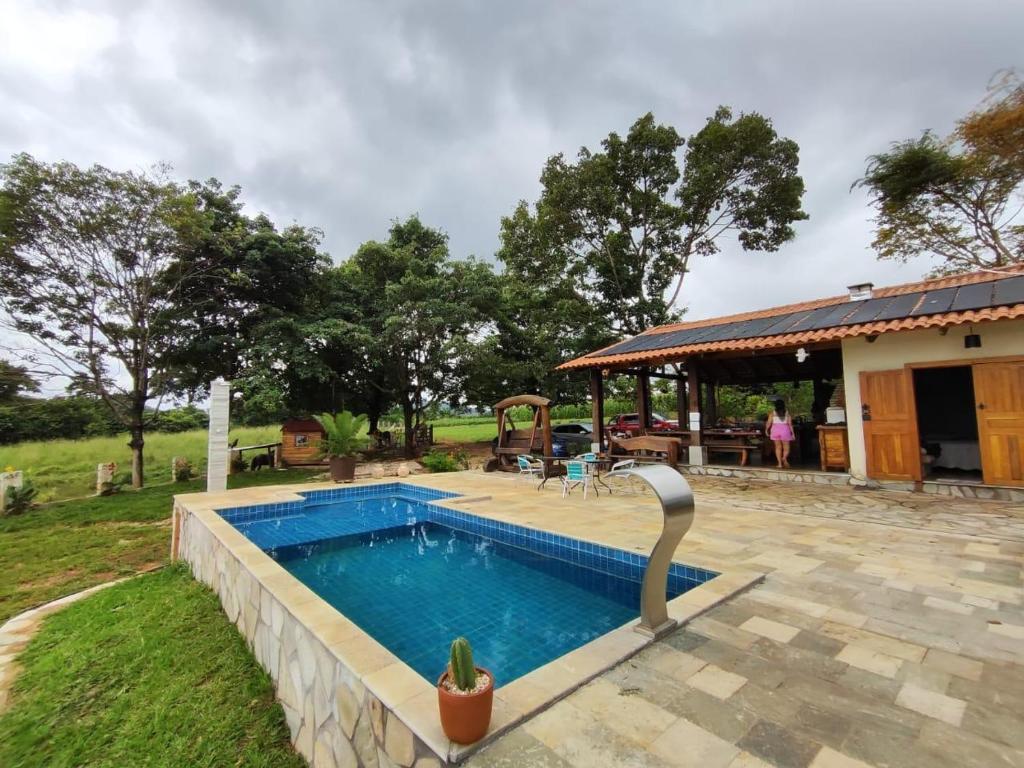 ein Schwimmbad in einem Hof neben einem Haus in der Unterkunft Estância Vista dos Pireneus in Pirenópolis