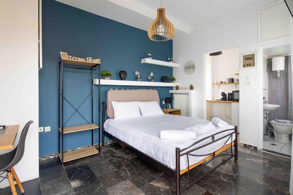 um quarto com uma cama e uma parede azul em Splendid view of Acropolis em Atenas