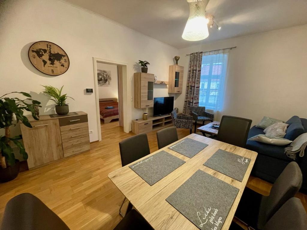 uma sala de estar com uma mesa e um sofá em Bobbys Gartenapartment em Krems an der Donau