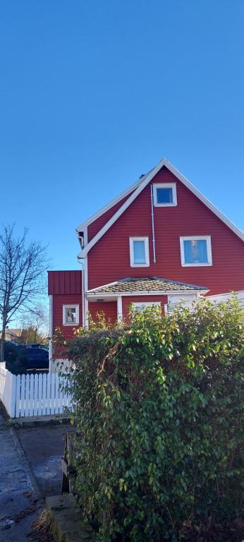 a red house with a white fence in front of it at Family home Stavanger in Stavanger