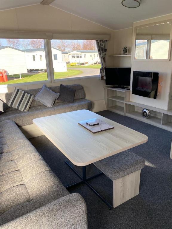 sala de estar con sofá y mesa en Family Caravan, Seton sands, Haven holiday village, en Port Seton