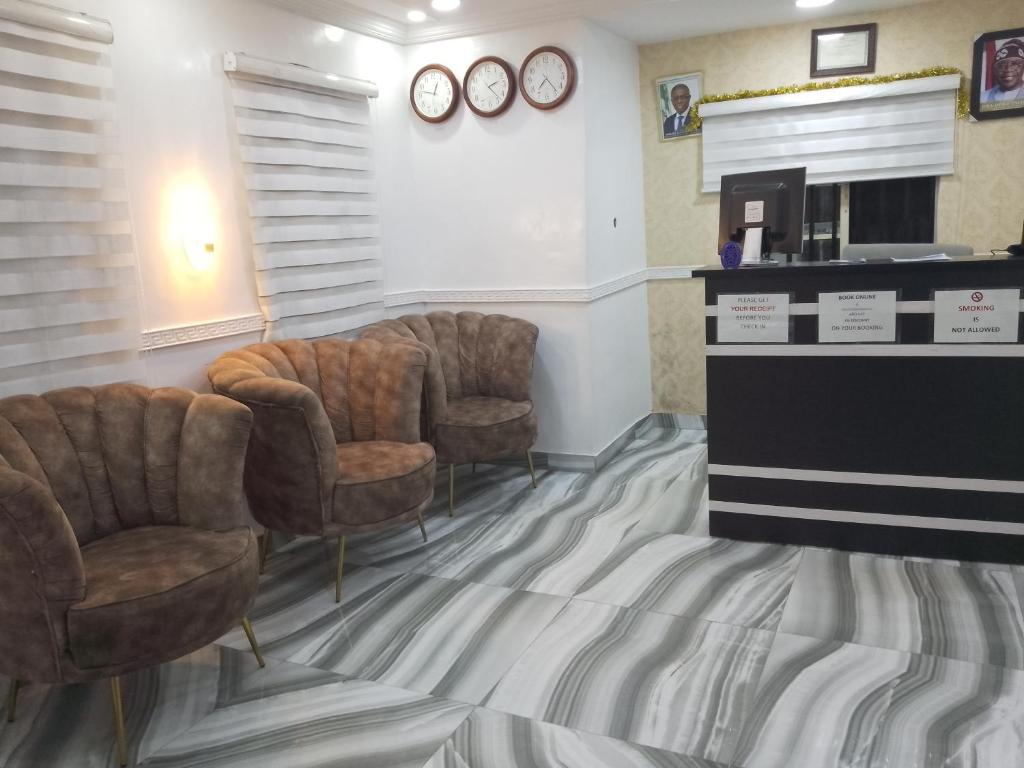 una sala de espera con 3 sillas y chimenea en Mid Way Best Hotel, en Lagos