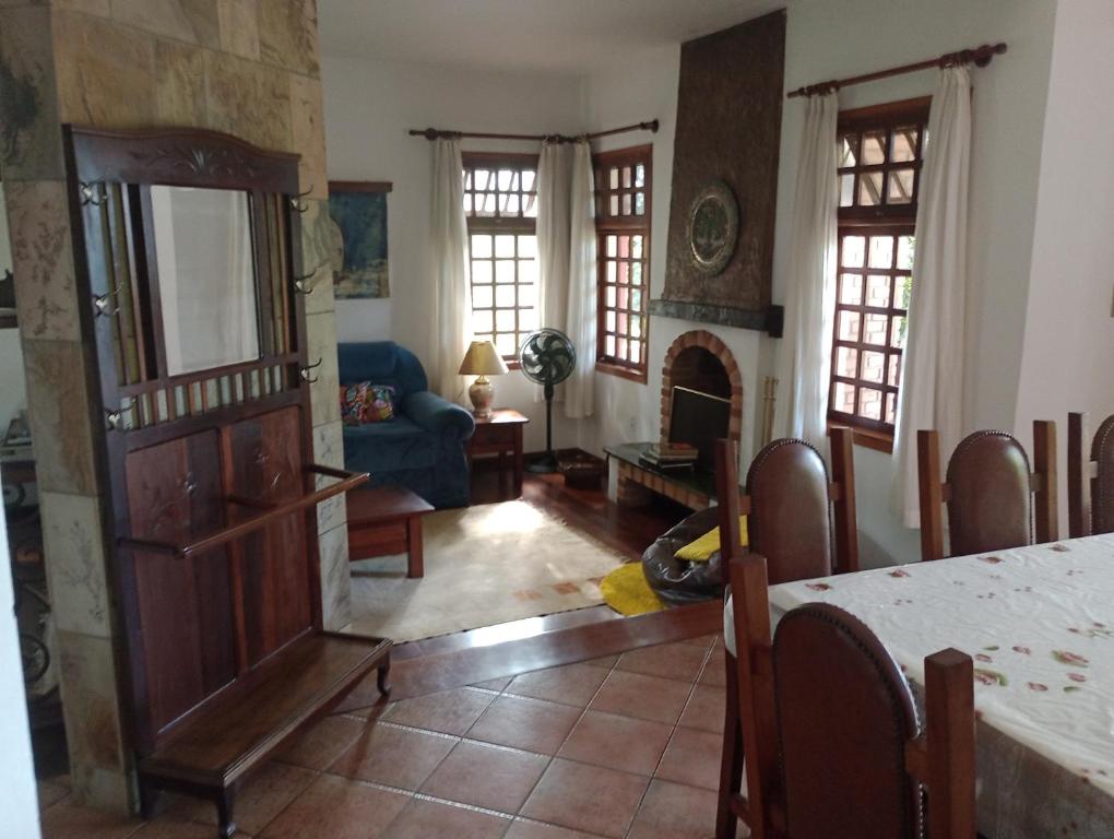 een woonkamer met een tafel en een open haard bij Casa vista lago Vitória Régia in Holambra