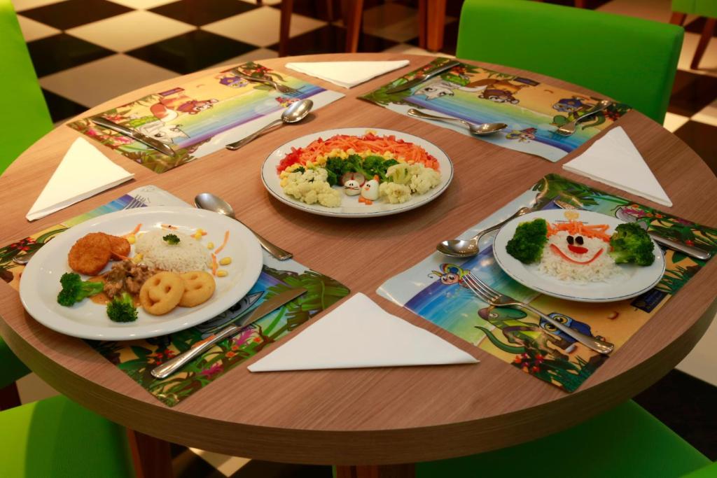 a wooden table with plates of food on it at Costao do Santinho Resort All Inclusive in Florianópolis