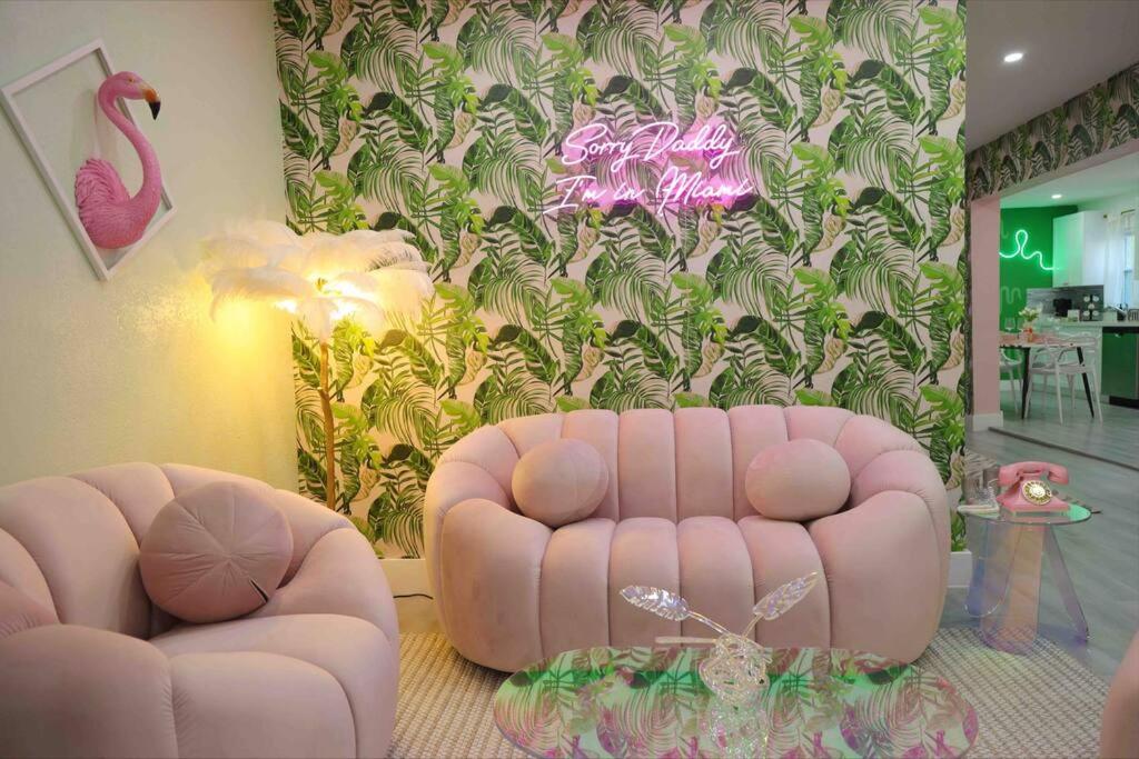 sala de estar con sofá rosa y pared de flamenco rosa en Tropical Oasis Modern Home with Backyard, en Miami