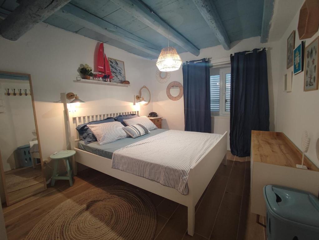 a bedroom with a large bed with blue curtains at Villa Kata in Rab