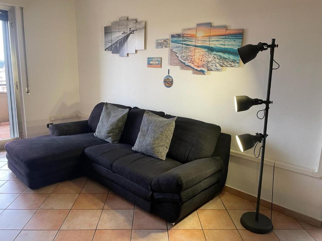 a living room with a couch and a lamp at Burago Flat in Burago di Molgora