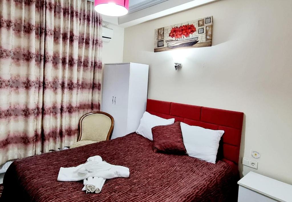 イスタンブールにある2 odalı 5 kişilik stüdyo daireのベッドルーム1室(赤いベッド1台、バスローブ付)