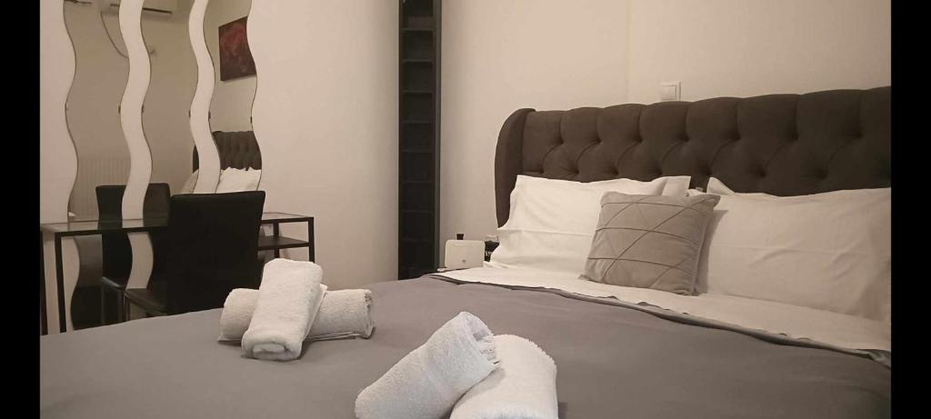 um quarto com uma cama grande e toalhas em Φωτεινό διαμέρισμα Πειραιας em Piraeus