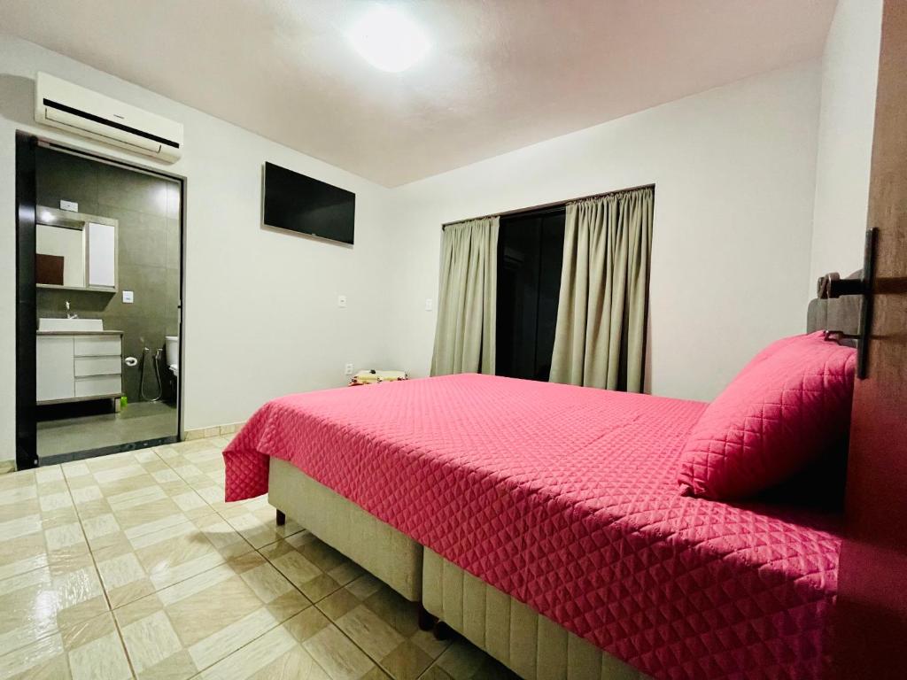 a bedroom with a pink bed and a window at Cantinho Gute Nacht 3 in Pomerode