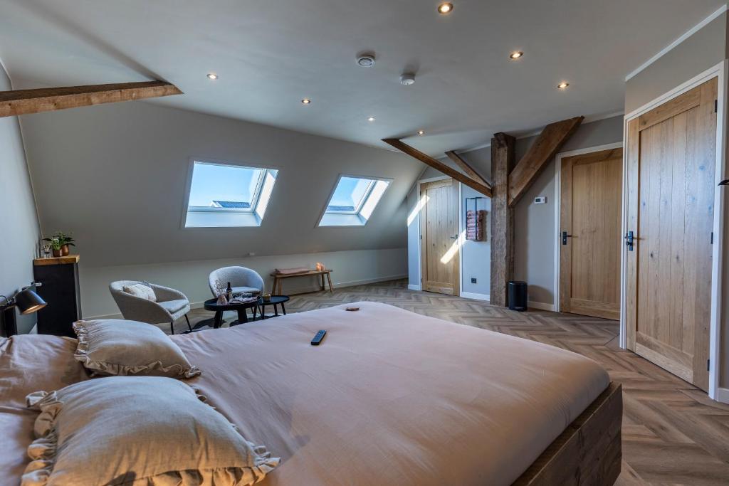 ein Schlafzimmer mit einem großen Bett in einem Zimmer mit Fenstern in der Unterkunft Jantje Slot Hoeve in Oosterzee